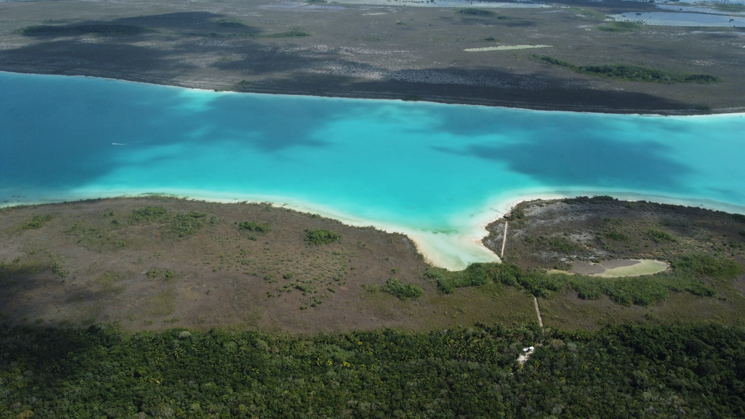 Aérea de la laguna turquesa de Bacalar encontrándose con la selva.